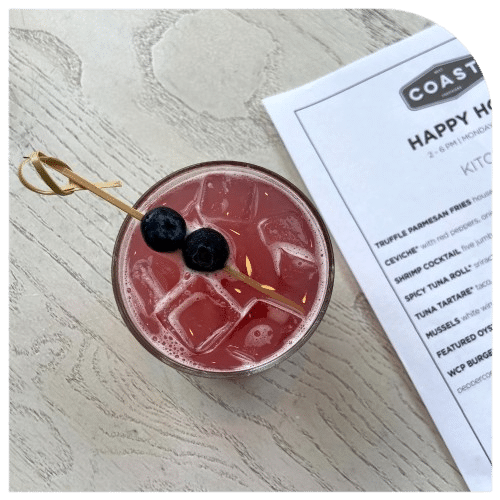 Drink on table next to happy hour menu