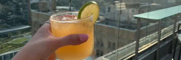 hand holding tropical drink on rooftop